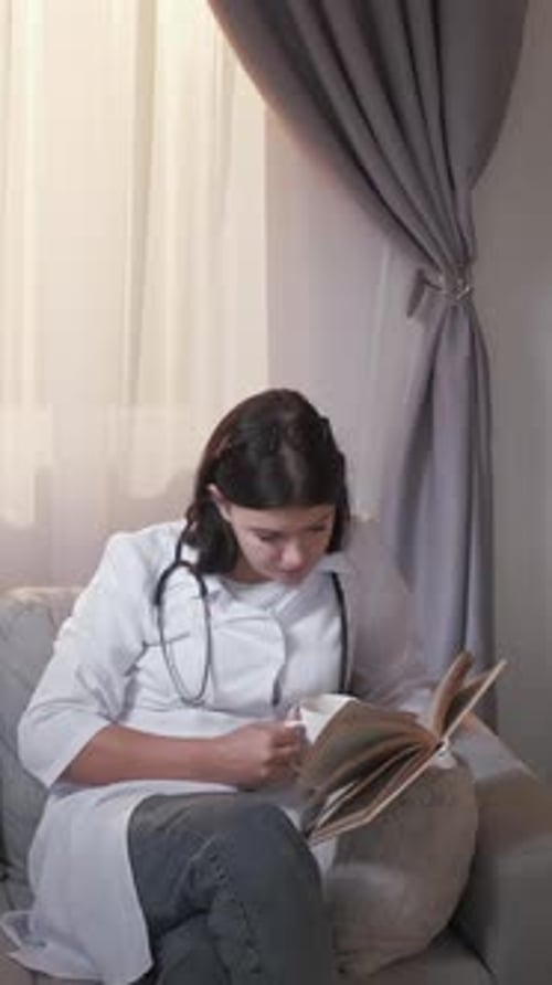 Doctor Reading Book and Drinking Indoors