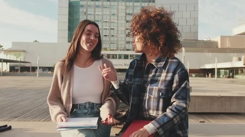 Students emotionally share the news and laugh while sitting next to the university