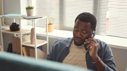 African American Man Talking on Mobile Phone in Office