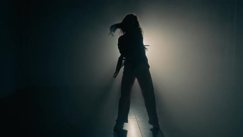 Silhouette of Female Dancer against Glowing Backlight