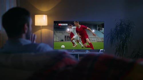 Man Watching Soccer on TV at Night Home