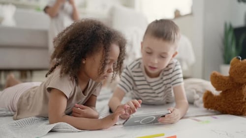 Children Playing Together with Mobile Phone on Floor