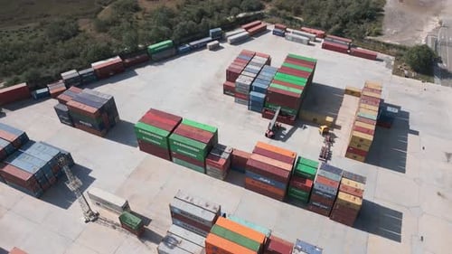 Luftaufnahme eines Containerterminals im Hafen, wo riesige Container auf ihre Reise warten