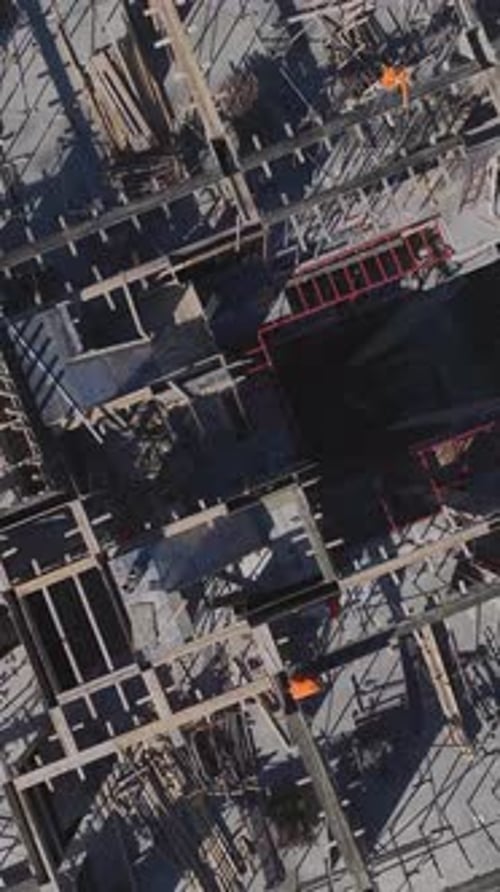 Vertical Video of Residential Construction in Progress With Workers Engaged in Metalwork and Wall