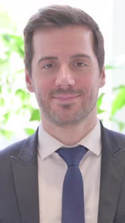 Portrait of Young Businessman Smiling at Camera in Office, vertical video