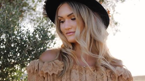 Gracious cute Blonde blue eyed woman dressed in Boho style posing under olive tree - close up