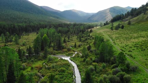 Winding River Flows Through Lush Green Valley Between Rolling Hills Media