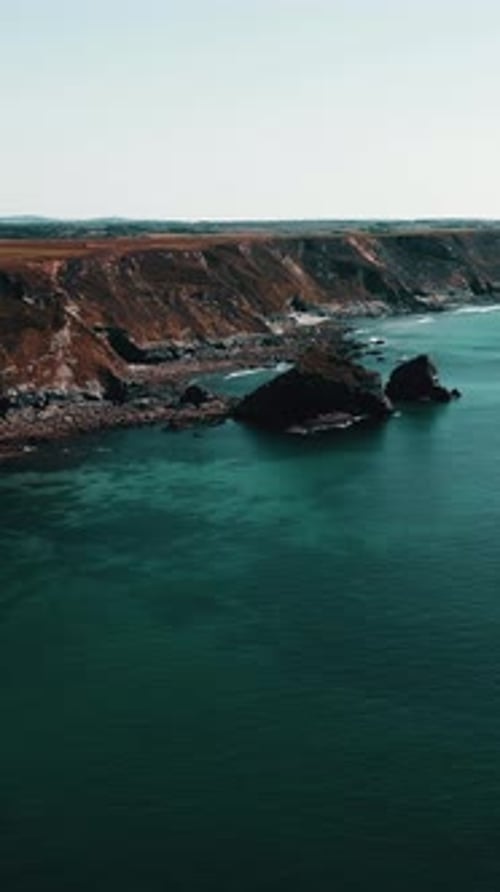 Rocks off the ocean coast line with turquoise water Vertical video