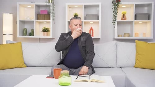 Alter Mann, der beim Husten Mund und Nase bedeckt.