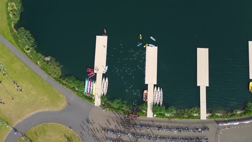 Triathlon at Dorney lake, triathletes running on the track and swimming