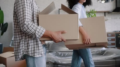 People Carry Cardboard Boxes into New Apartment