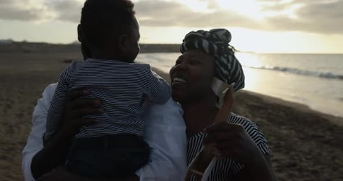 African Parents Having Playful Time with Little Child Outdoor on the Beach