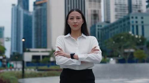 Charming Girl Standing In the Street and Posing with Hands Looking at the Camera Outside Wearing