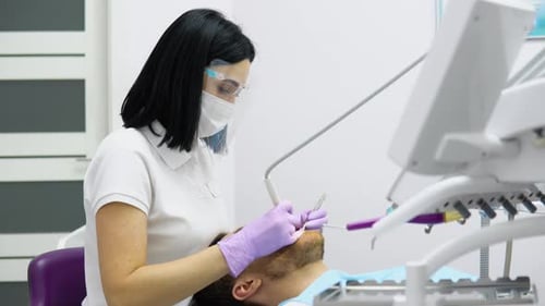 Dental Professional Treating Patient in Modern Office