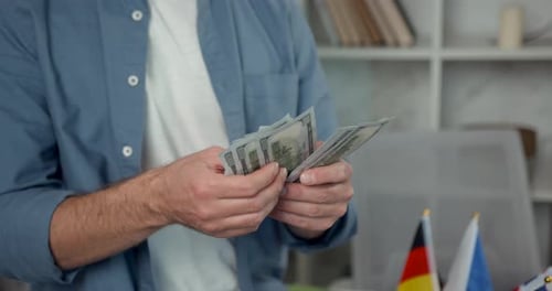 Man counting US Dollar Bills Indoors