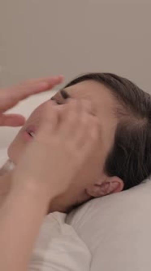 Woman Lying Down Massaging Temples For Pain Relief