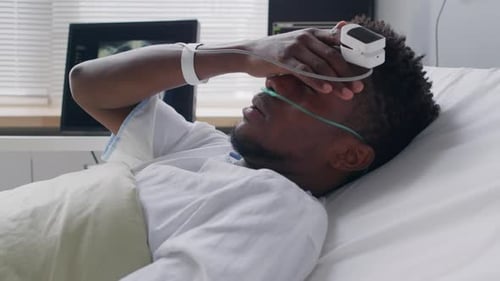 Black Man with Headache in Hospital Bed