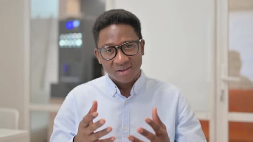 Blogging African Businessman Doing Video Chat in Office