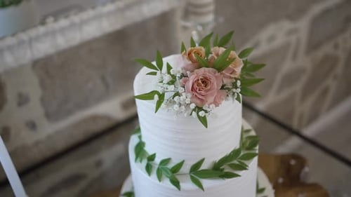 Wedding Cake Decorated with Roses and Green Leaves