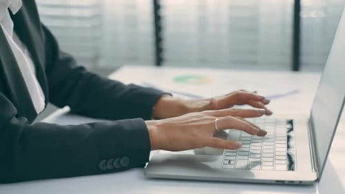 Woman Typing on Laptop at Bright Desk