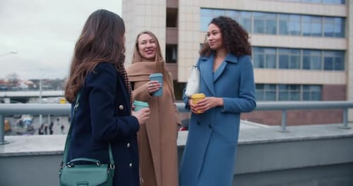 Friends Chatting Over Coffee in Urban Setting