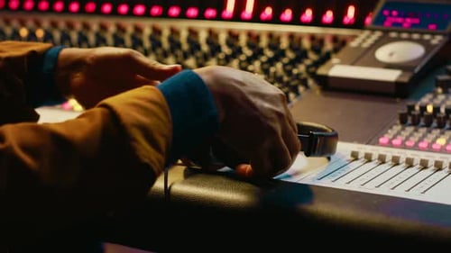 African American Sound Engineer Using Headphones to Listen to Audio Recordings