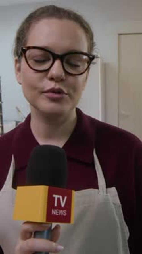 Woman Reporter with Microphone in Kitchen