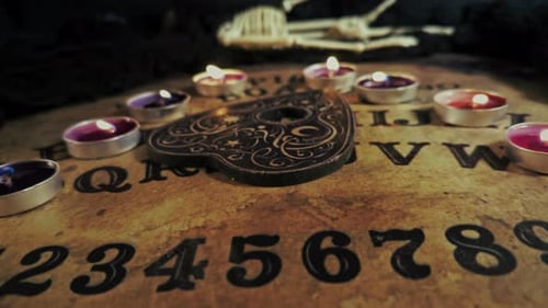 Ouija Board with Planchette and Candles Close Up