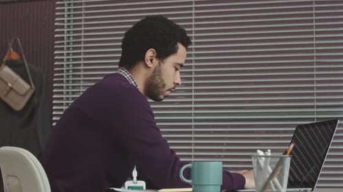 Middle Eastern Programmer Working on Laptop in Office