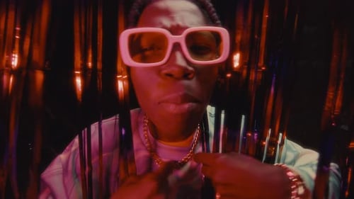 Black Rapper Giving Performance against Shimmering Tinsel Curtains