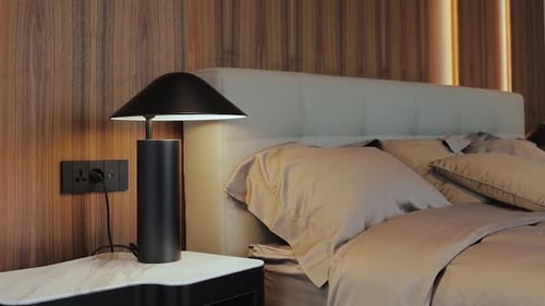 Dormitorio moderno con elegante lámpara en hermosos tonos y texturas neutros