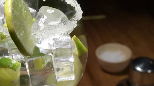 Close up water filling Fresh cocktail lemonade glass spinning , drink with soda, lemon slice, ice an