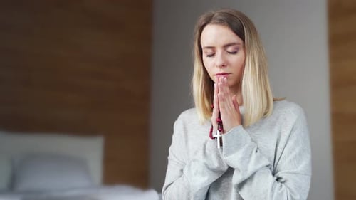 Woman Praying with Rosary in Bedroom
