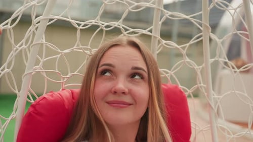 Smiling Teen Girl Relaxing in Hanging Chair