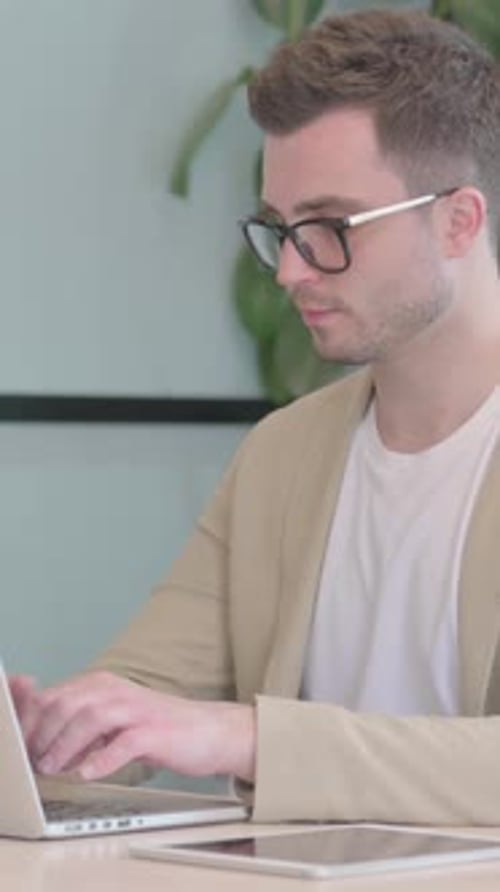 Excited Man Working on Laptop at Desk