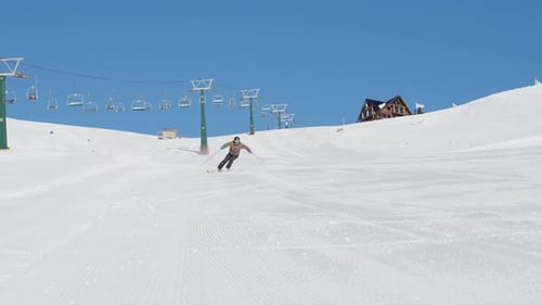 Skier Skiing Down Ski Slope At Resort