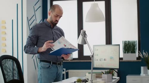 Young Adult Analyzing Business Data in Modern Office