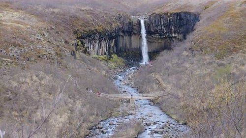 Water falling down over the Svartifoss waterfall in Iceland in an autumn landscape.