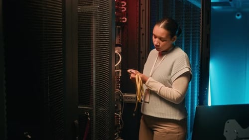 Woman Inspecting Cables in a Server Room