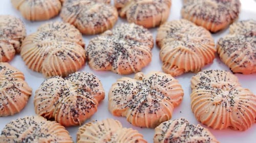 Top View of Rotating Poppy Seed Cookies on White Surface