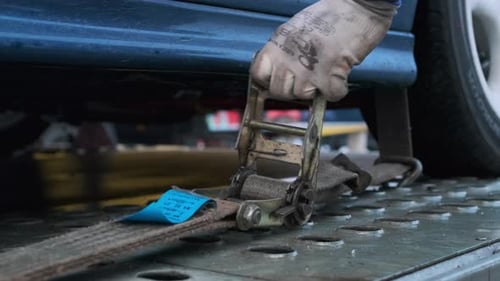 Tightening Ratchet Strap to Secure Vehicle to Trailer