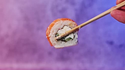 Take and Hold One Sushi Roll Using Sticks For Sushi CloseUp