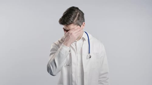Distressed Doctor Holds Face in Hands