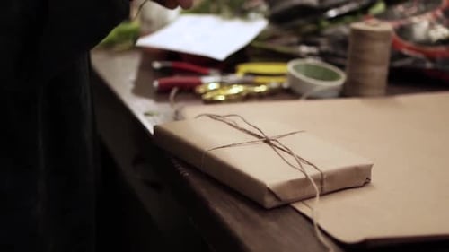 Florist Wrapping a Gift with Twine and Brown Paper