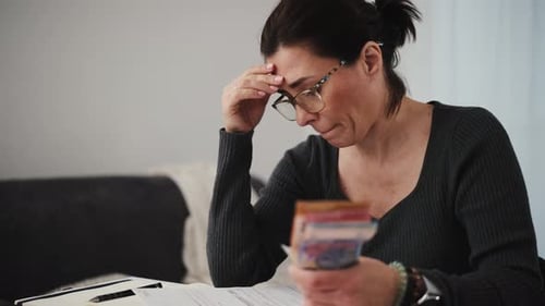Woman Focuses On Reviewing Bills