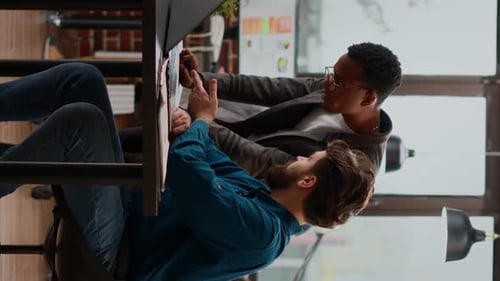 Two Colleagues Collaborate on Project in Urban Workplace