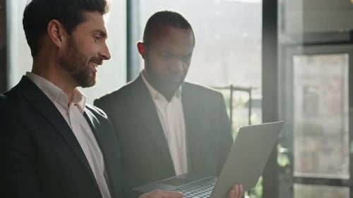 Businessmen Discussing Technology in Modern Office