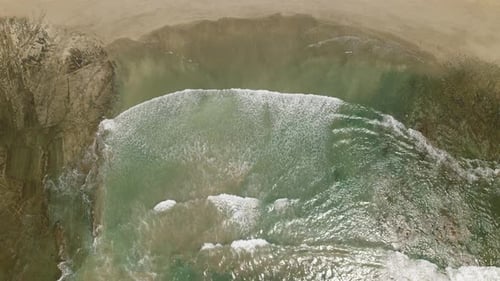 Aerial view of turquoise ocean waves breaking along Costa Rican beach