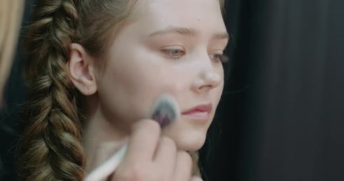 Portrait of a Pretty Girl Makeup Artist Applies Makeup for a Young Model Studio Shooting Beauty