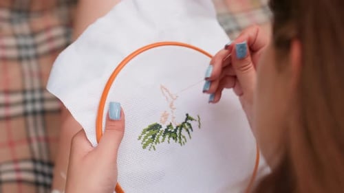 Close Up Rear View Of Designer Embroidering Tree Design On Fabric Outdoors